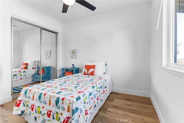 bedroom featuring hardwood / wood-style flooring, ceiling fan, and a closet