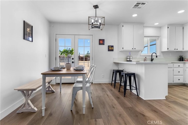 dining space featuring hardwood / wood-style floors, sink, plenty of natural light, and french doors