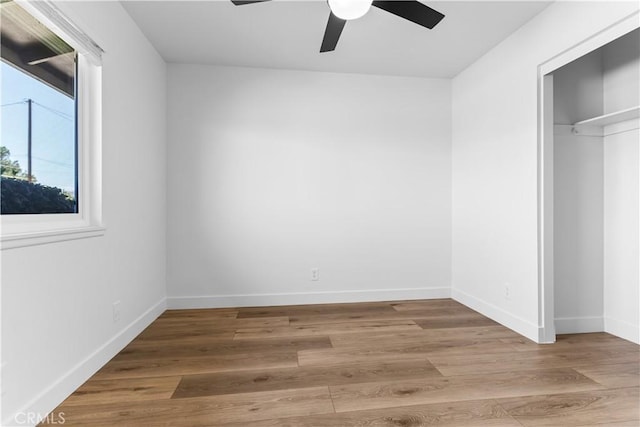 unfurnished bedroom featuring hardwood / wood-style floors, a closet, and ceiling fan