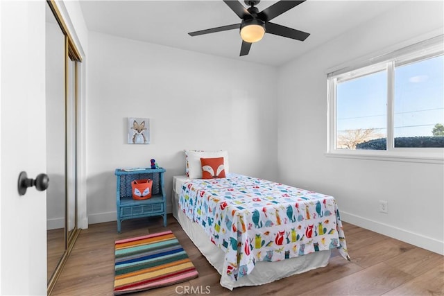 bedroom with hardwood / wood-style flooring, ceiling fan, and a closet