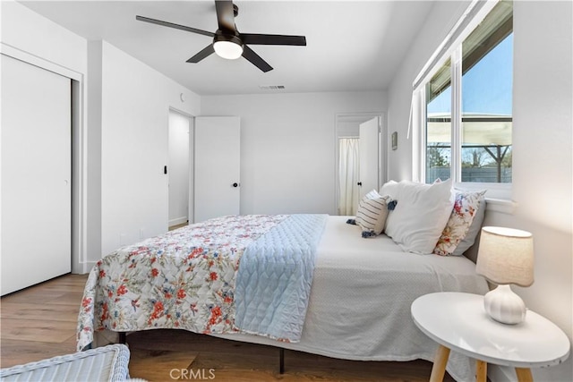 bedroom with hardwood / wood-style flooring, ceiling fan, and a closet