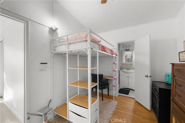 bedroom with sink and light hardwood / wood-style flooring