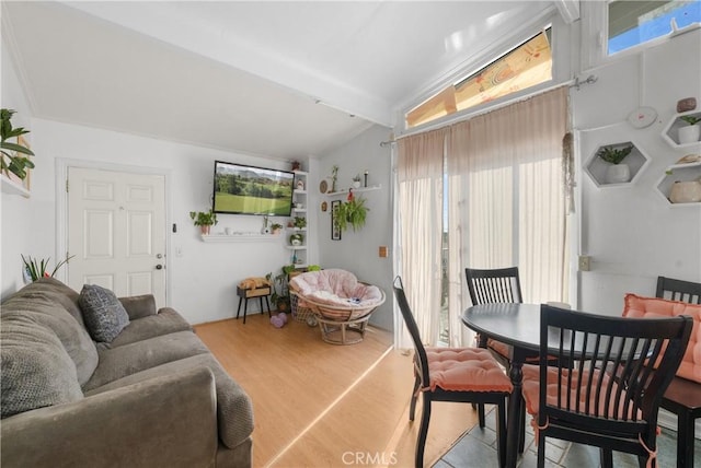 living room with light hardwood / wood-style floors and vaulted ceiling with beams