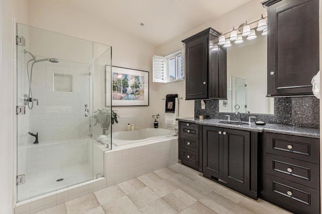 bathroom with tasteful backsplash, vanity, and independent shower and bath