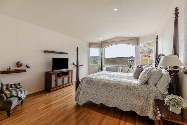 bedroom with vaulted ceiling and light wood-type flooring