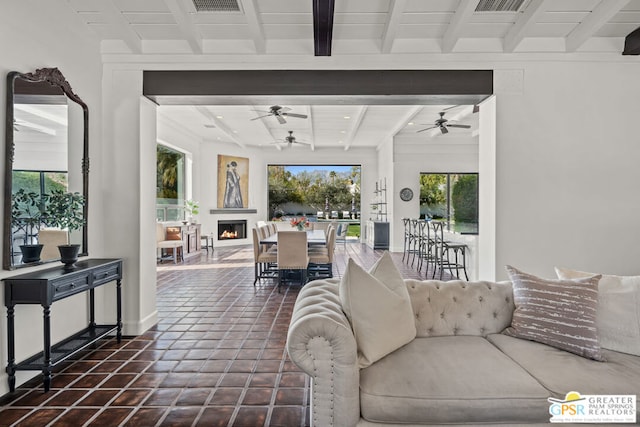 living room with beamed ceiling, dark tile patterned floors, and ceiling fan