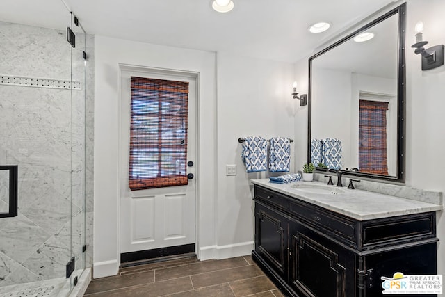 bathroom featuring vanity and a shower with door