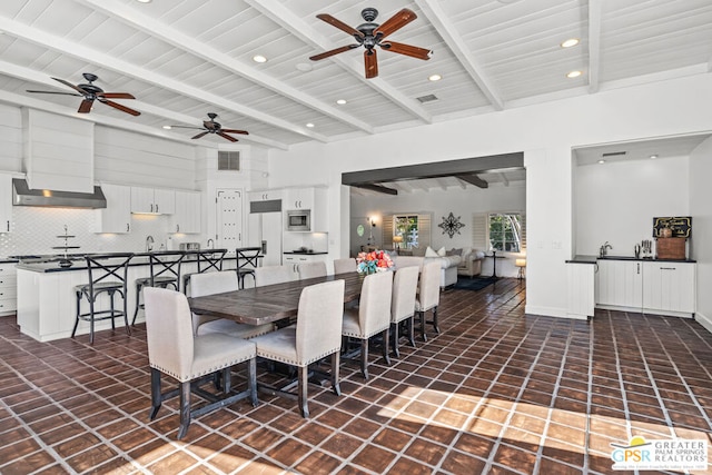 tiled dining area featuring beamed ceiling