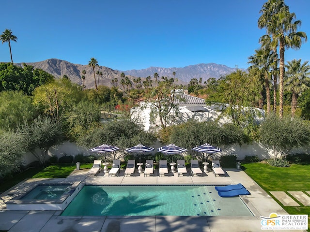 view of swimming pool featuring a mountain view, a patio, and an in ground hot tub