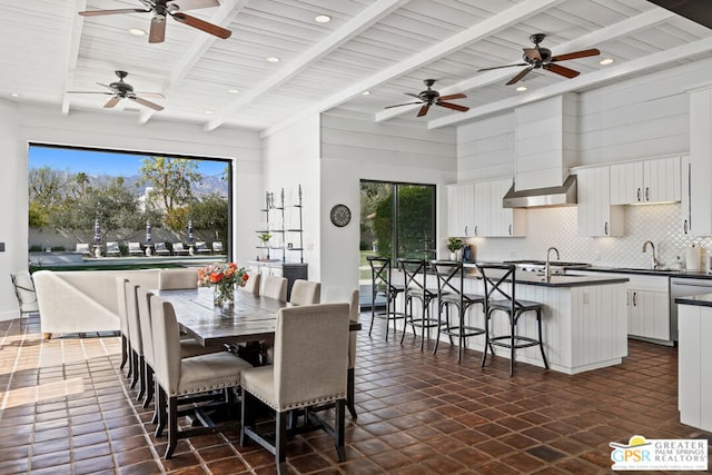 dining area featuring beamed ceiling, sink, and wooden ceiling