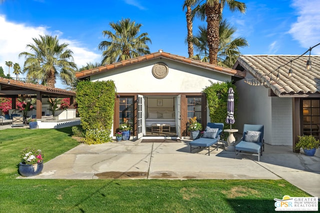 back of house with a patio area and a lawn