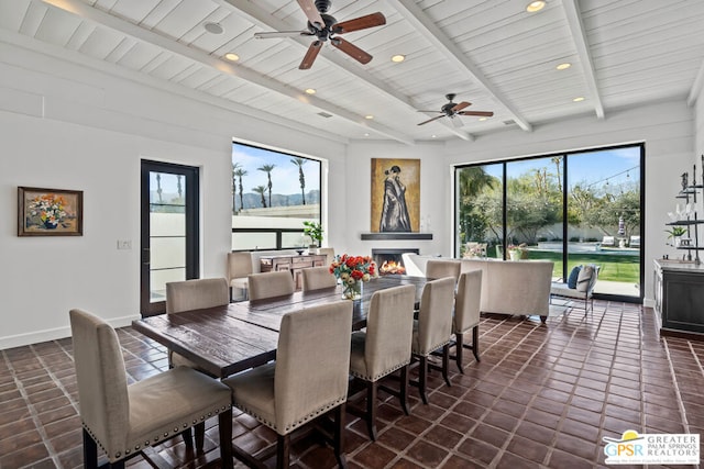 dining space featuring dark tile patterned flooring, wood ceiling, and beamed ceiling