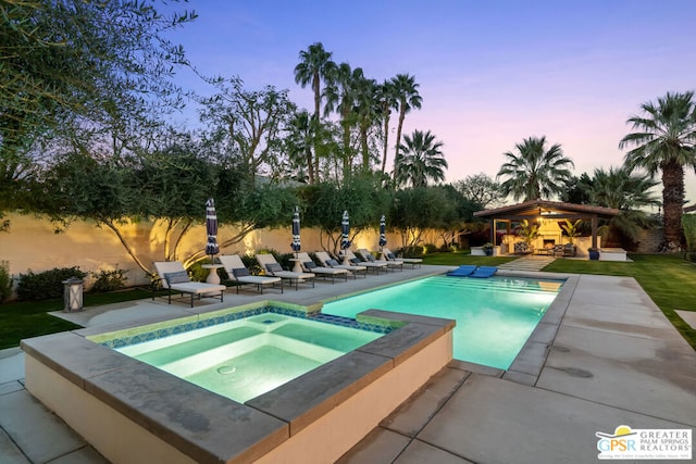 pool at dusk featuring a gazebo, a patio area, and an in ground hot tub