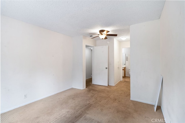 carpeted empty room with ceiling fan and a textured ceiling