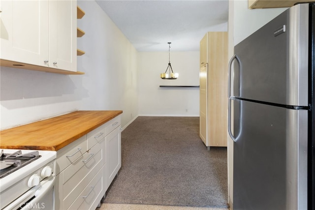 kitchen with pendant lighting, wood counters, stainless steel refrigerator, and white cabinets