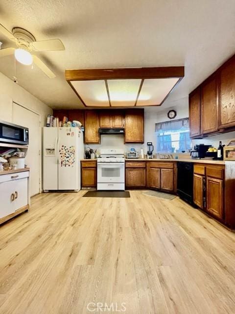 kitchen featuring ceiling fan, white appliances, and light hardwood / wood-style floors