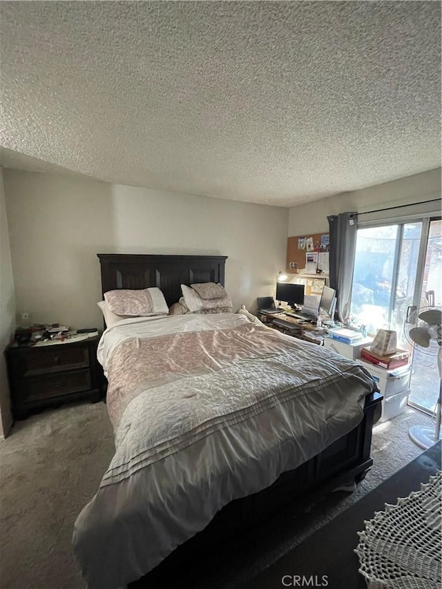 carpeted bedroom with access to exterior and a textured ceiling