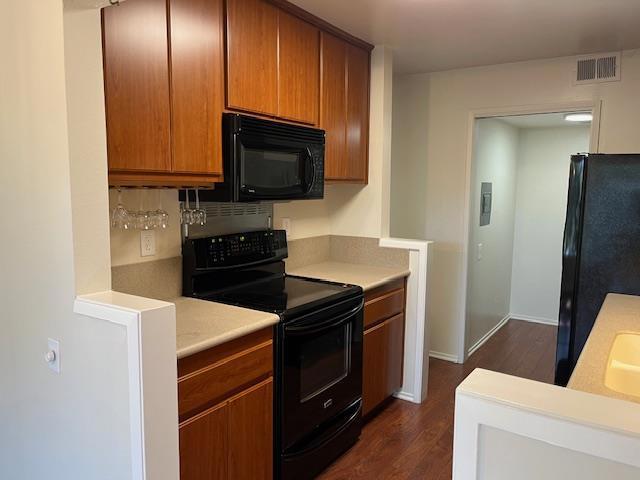 kitchen with backsplash, dark hardwood / wood-style flooring, and black appliances