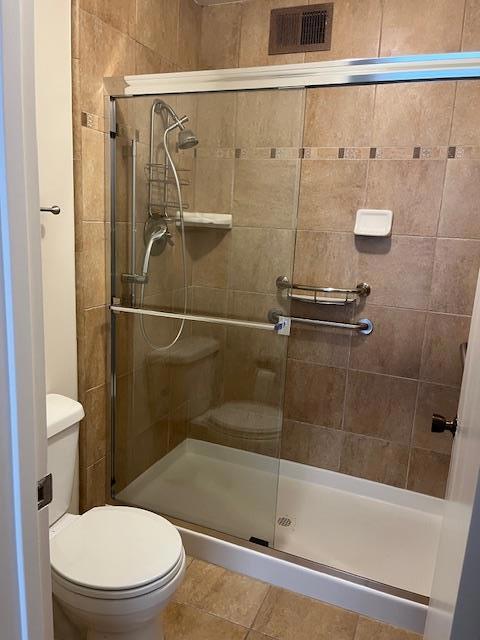 bathroom featuring an enclosed shower and toilet