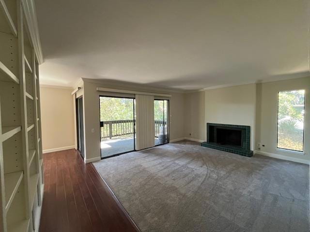 unfurnished living room featuring dark hardwood / wood-style flooring, crown molding, and a fireplace