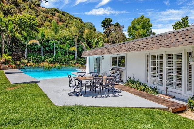 view of swimming pool featuring a patio and a yard