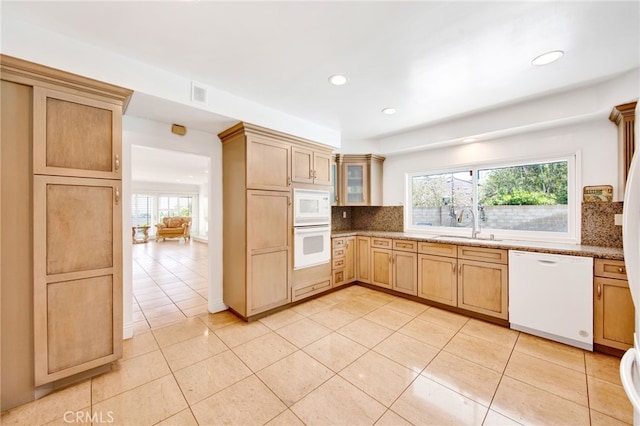 kitchen featuring sink, light brown cabinets, light stone counters, and white appliances