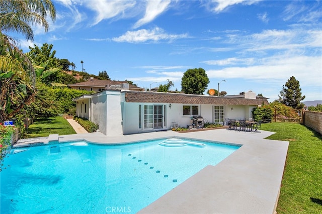 view of pool featuring area for grilling, a lawn, a patio, and french doors