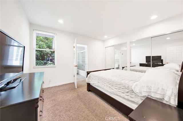 bedroom with multiple closets, ensuite bathroom, and carpet flooring