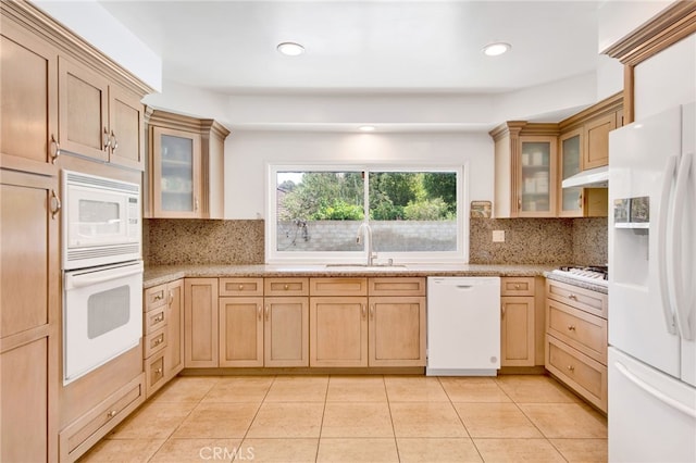 kitchen with sink, white appliances, decorative backsplash, and light brown cabinets