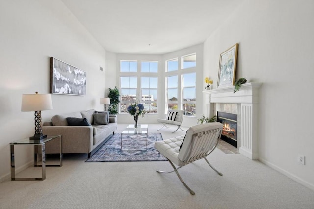 carpeted living room featuring a tiled fireplace