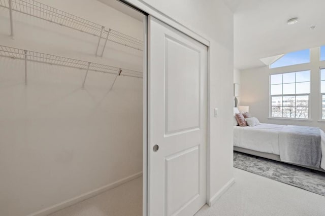 bedroom with light colored carpet and a closet