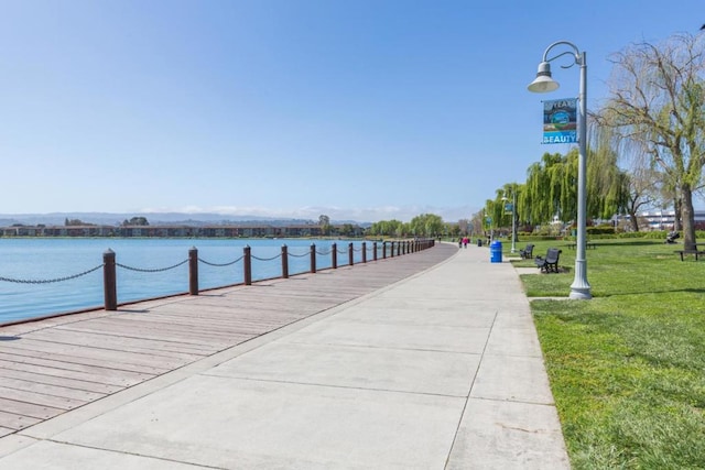 view of property's community featuring a water view and a lawn