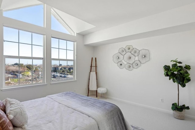 carpeted bedroom featuring lofted ceiling and multiple windows