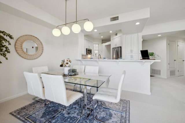 carpeted dining area with sink