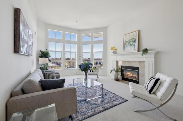 living room with a tiled fireplace and carpet floors