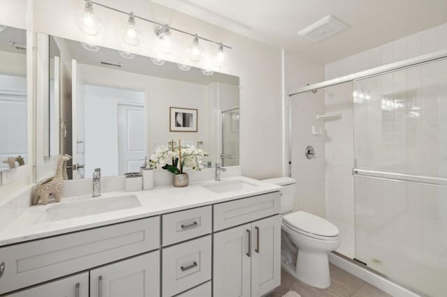 bathroom featuring walk in shower, vanity, toilet, and tile patterned flooring