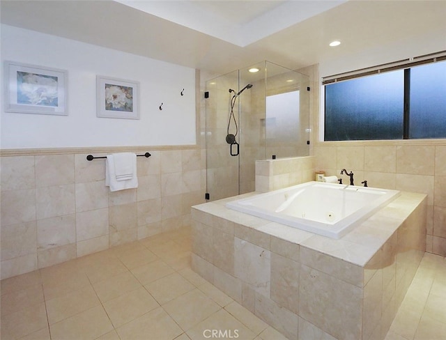 bathroom with tile patterned flooring, separate shower and tub, and tile walls