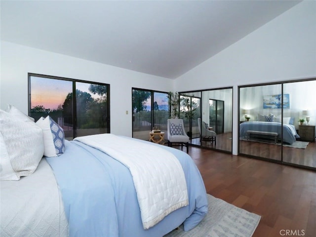 bedroom featuring dark hardwood / wood-style flooring, access to exterior, and high vaulted ceiling