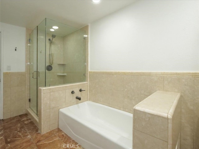 bathroom with separate shower and tub and tile walls