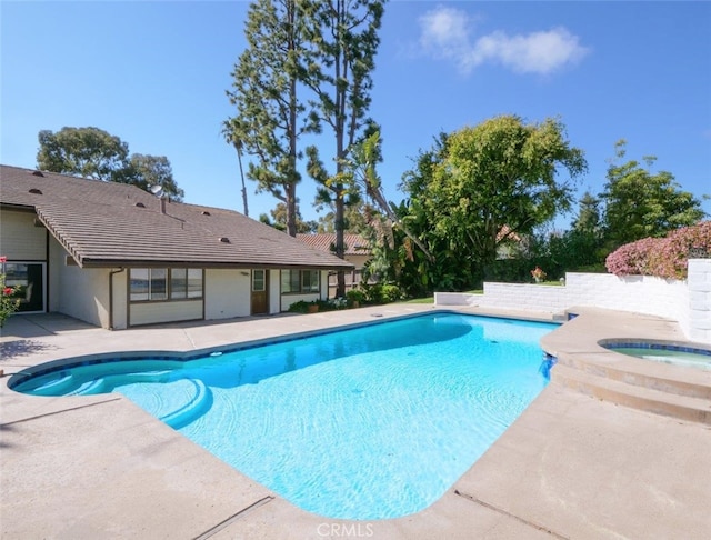 view of swimming pool with a patio and an in ground hot tub