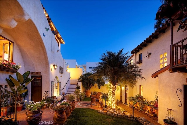 yard at dusk featuring a patio area and stairs