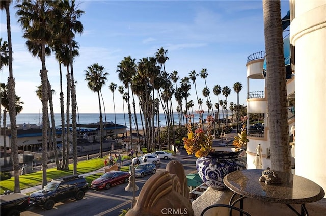 exterior space with curbs, a water view, and sidewalks