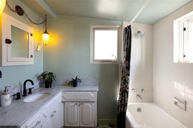 bathroom with shower / bath combination with curtain, a healthy amount of sunlight, and vanity