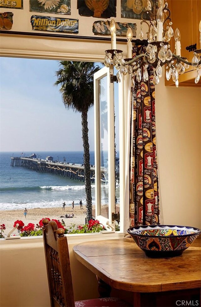 dining space featuring a water view and a beach view