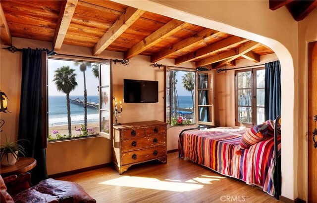 bedroom featuring beam ceiling, wood ceiling, and light hardwood / wood-style floors