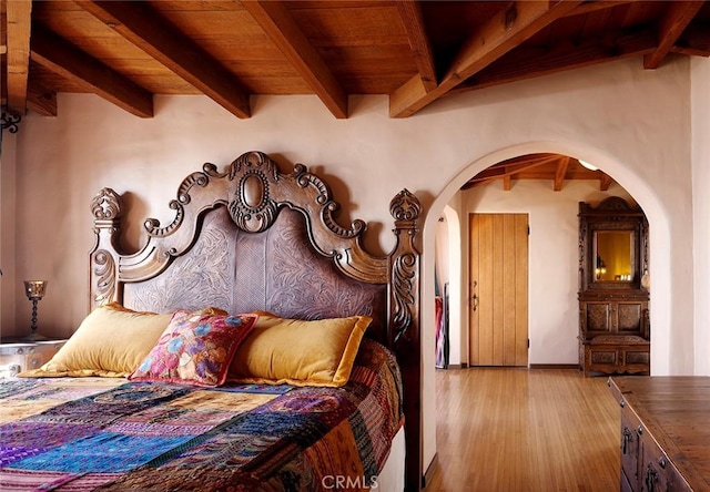 bedroom with beamed ceiling, light hardwood / wood-style floors, and wooden ceiling