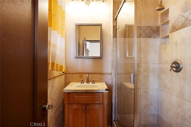 full bathroom with tiled shower and vanity