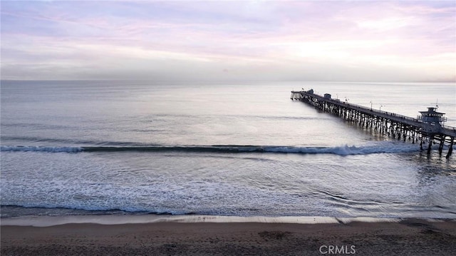 dock area featuring a beach view and a water view