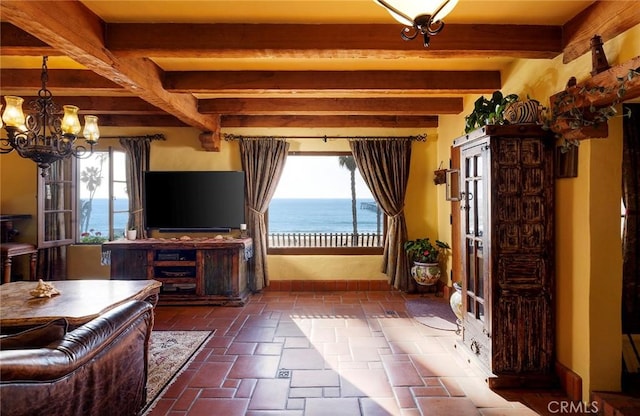 unfurnished living room with beam ceiling, a notable chandelier, and baseboards