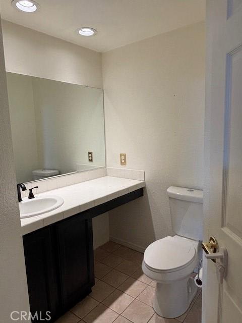 bathroom featuring vanity, tile patterned floors, and toilet